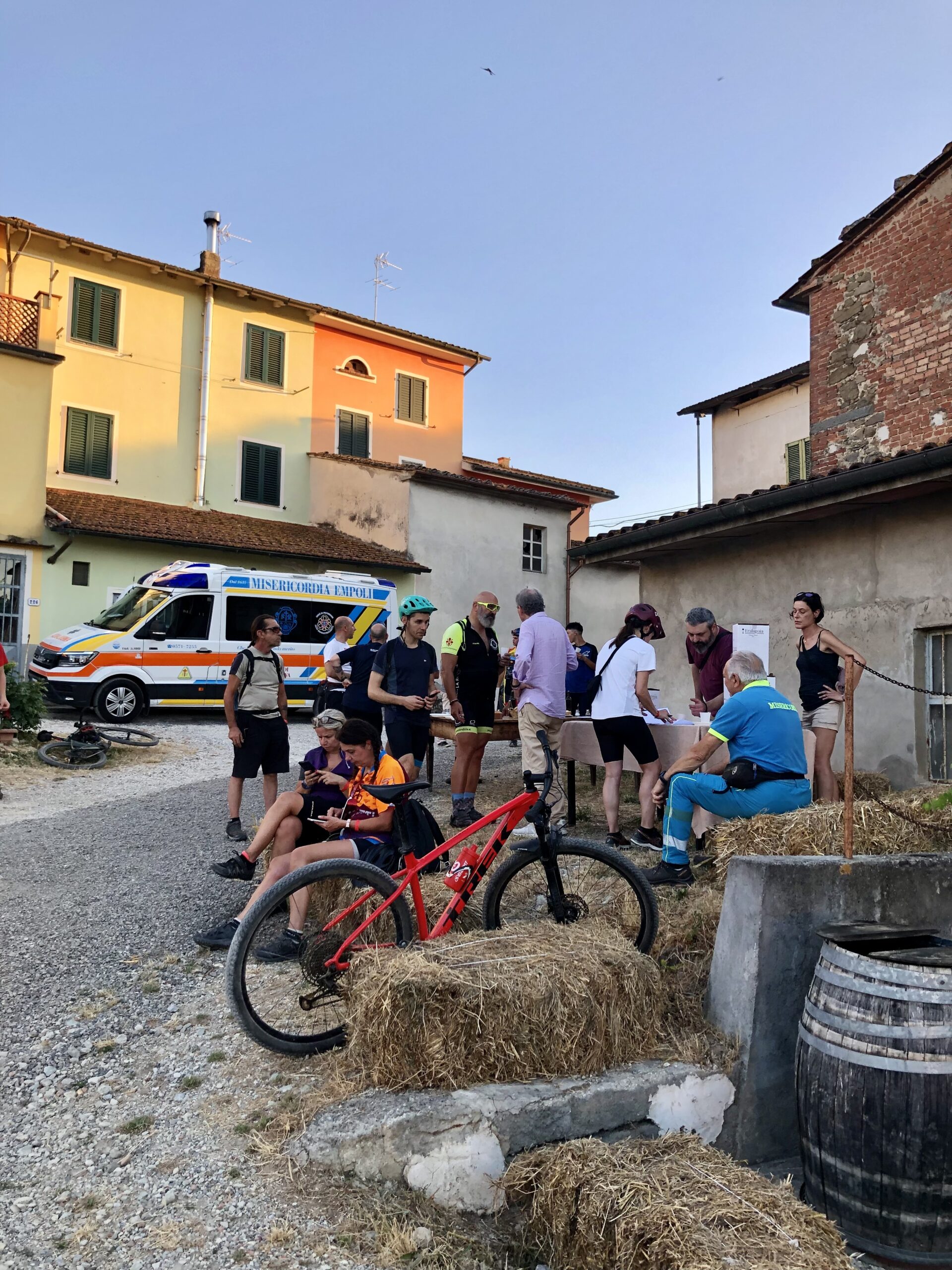 ciclisti con bici e vino in mano